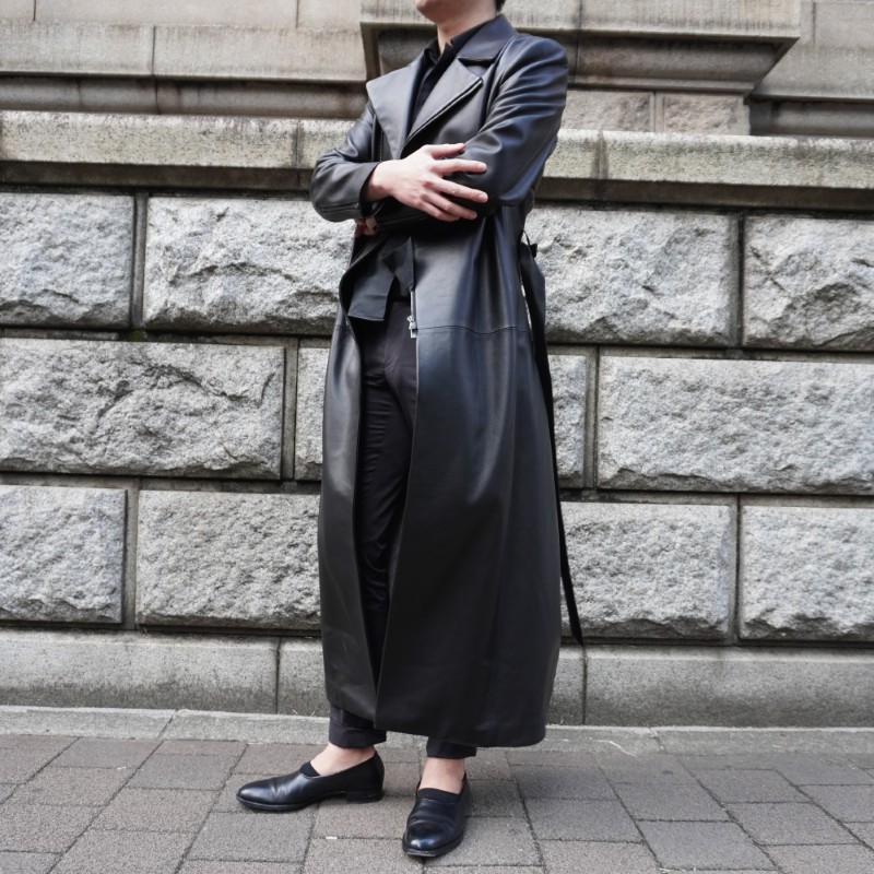オーダーメイドのロングレザージャケットコートを着ている