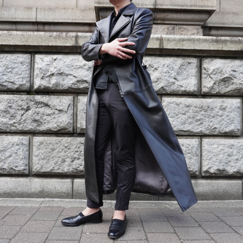 オーダーメイドのロングレザージャケットコートを着て腕を組んでいる