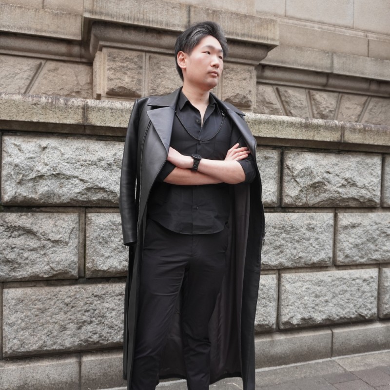 オーダーメイドのロングレザージャケットコートを羽織っている