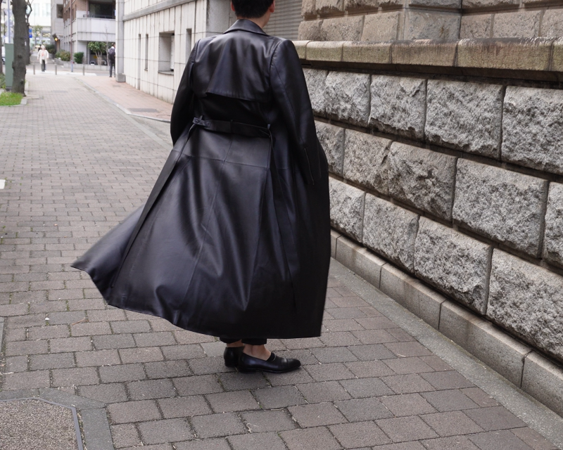 オーダーメイドのロングレザージャケットコートを着て振り返る