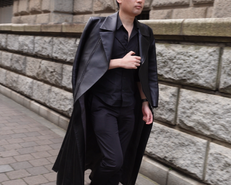 ゲームの世界感を再現したオーダーメイドのロングレザージャケットコートを着て歩いている